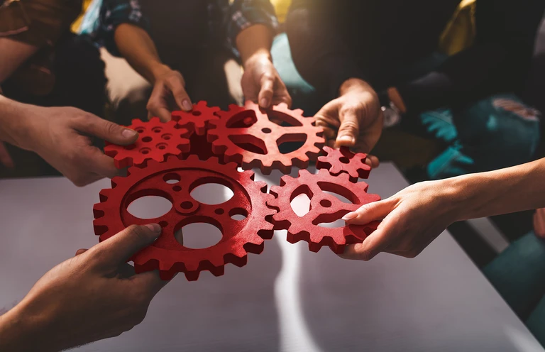 people are holding gears in their hands and stack them together